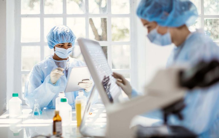 People in masks work in a lab
