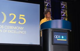 Margaret Beale Spencer stands at an APS 2025 branded podium as she gives her remarks.