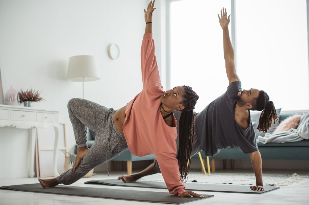 Couple doing yoga in their living room