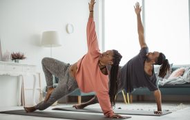 Couple doing yoga in their living room