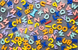 Colorful alphabet letters on gray background and texture.