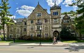 People walking in front of a large building on the University of Michigan campus