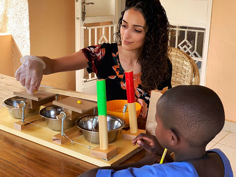Amir and a Ugandan boy sitting at a table doing an experiment.