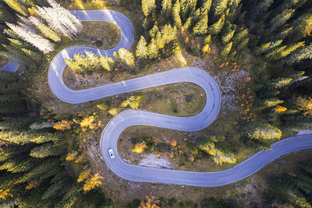 Car on empty serpentine road, Dolomites.
