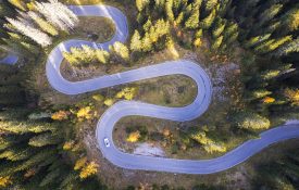 Car on empty serpentine road, Dolomites.