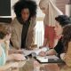 Close up of a young Black woman leading a diverse team meeting.
