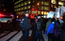 A police officer stands next to a photographer during a protest after Eric Garner's death.