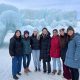 Emily Finn and her lab stand in front of large ice formations.
