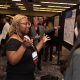 Researchers presenting their posters, talking with their hands and pointing to the poster board.