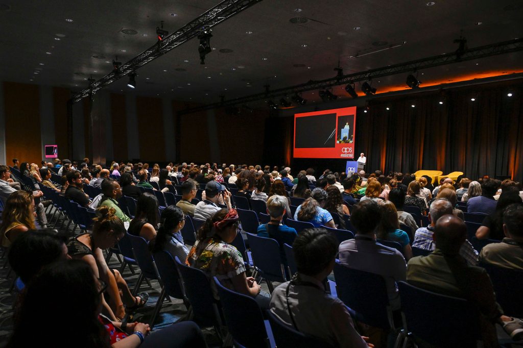 A shot from behind a packed crowd at an APS 2026 plenary.