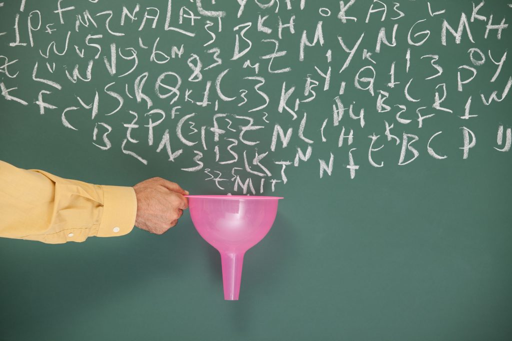 Hand holding a funnel to a chalkboard with letters, imitating filtering through the funnel.