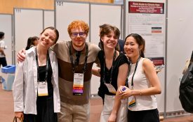 Four convention attendees smile together at the camera.