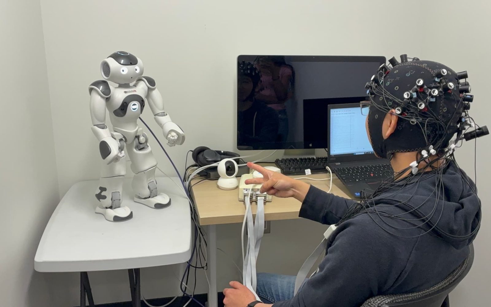 YC playing rock, paper, scissors with a NAO robot while having his brain activity measured using fNIRS.