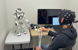 YC playing rock, paper, scissors with a NAO robot while having his brain activity measured using fNIRS.