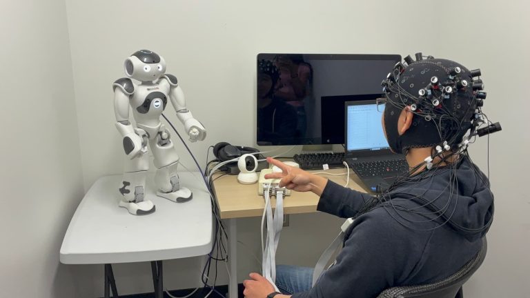 YC playing rock, paper, scissors with a NAO robot while having his brain activity measured using fNIRS.