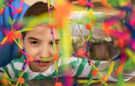 A female nurse works with an autistic boy using colorful sensory toys to develop motor skills.