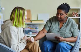 Psychologist working with upset girl at office.