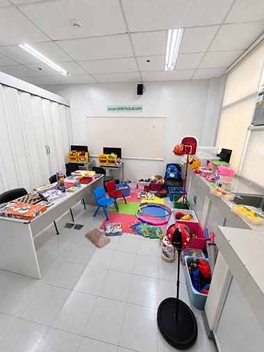 A photo of a white classroom with colorful toys and activities.